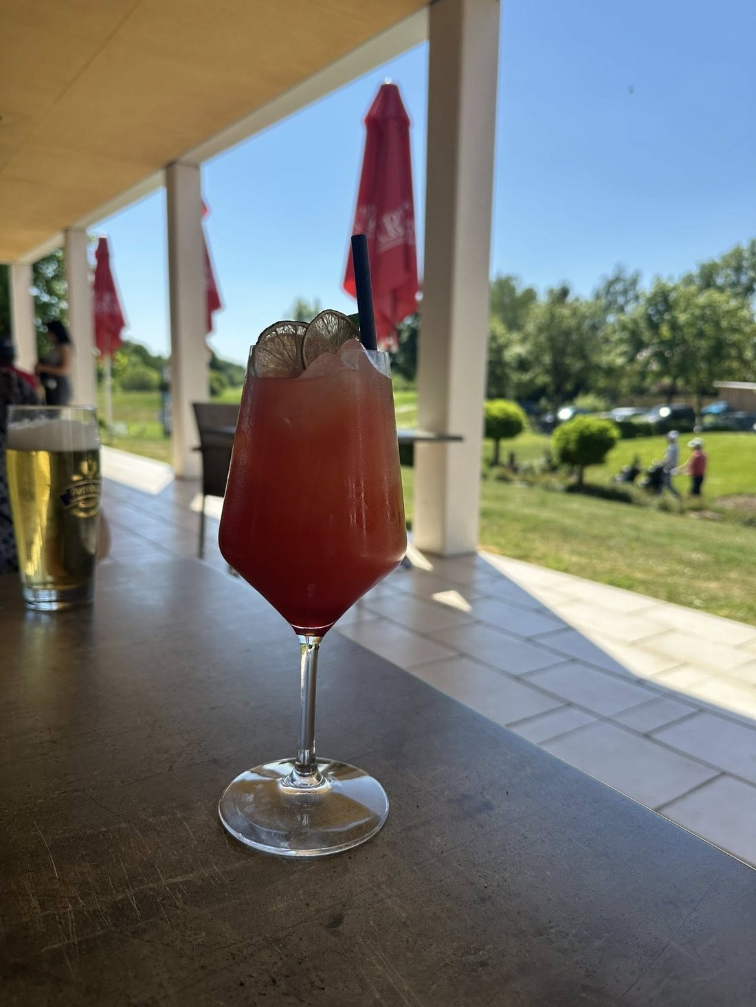 Roter Drink mit Limettenscheiben auf der Terrasse