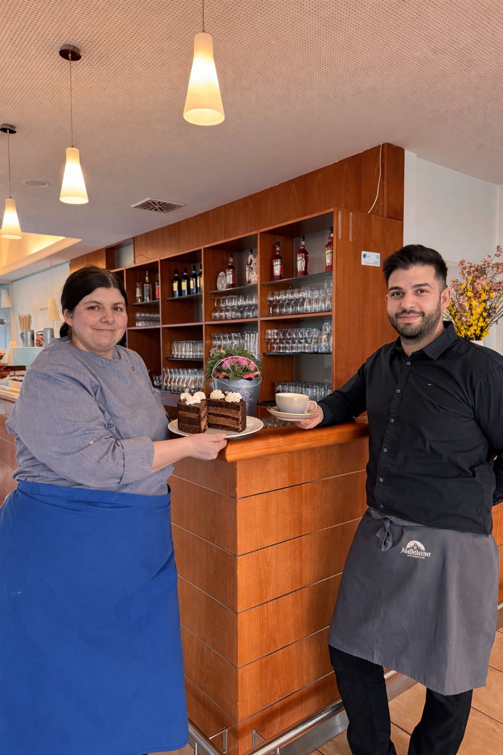 Café-Team an der Theke mit Kuchen und Kaffee